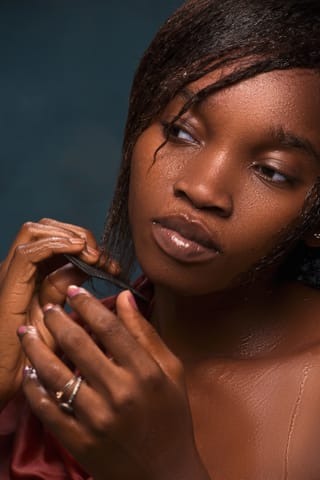A portrait of a woman with braided hair, looking off to the side with a contemplative expression.