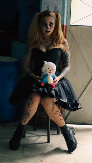 Una muñeca en una habitación abandonada, con un enfoque en la apariencia desgastada y polvorienta de la muñeca.