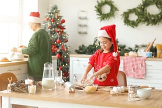 Child baking christmas cookies in kitchen