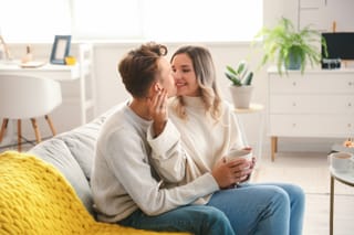 Couple cuddling on couch at home