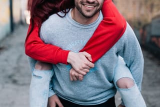 Couple enjoying piggyback ride in city