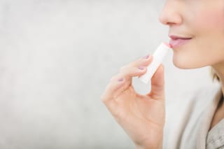Person applying lip balm close-up
