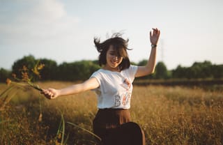 Woman dancing in sunlit field