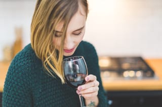 Woman holding wine glass indoors
