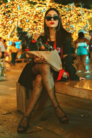 Mujer sentada bajo luces festivas con pantimedias de lunares