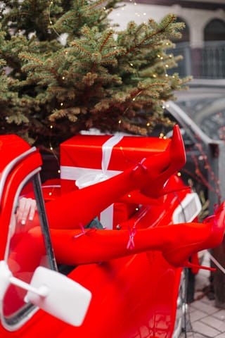 Small Christmas tree and wrapped gifts are carried on a bright red bicycle