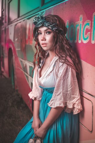 Woman wearing a colorful bohemian skirt and white blouse.