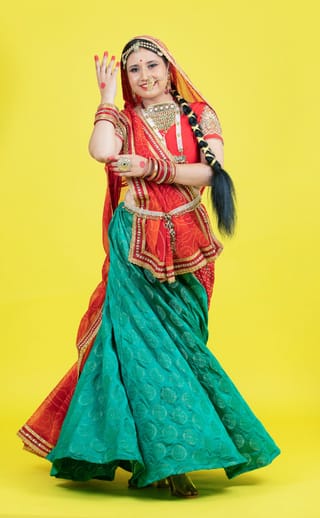 Woman performing in a colorful traditional dance dress.