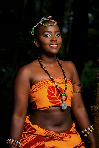 Woman wearing an orange traditional outfit and colorful jewelry.