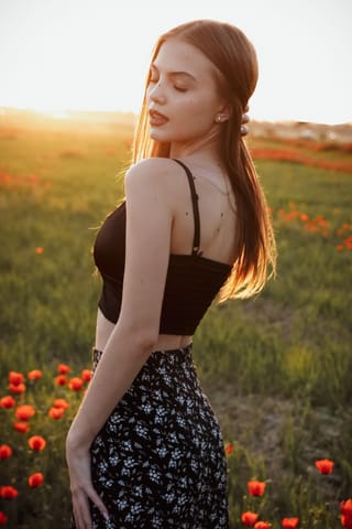 Woman posing in a wildflower field at sunset.