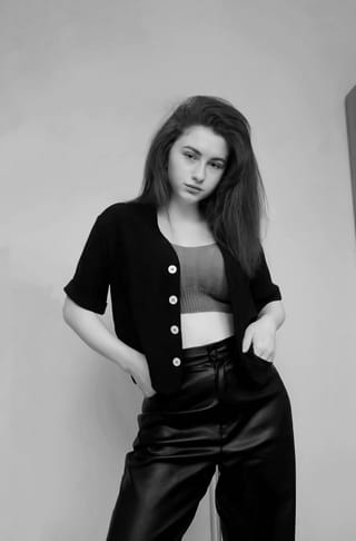 Black-and-white studio portrait of a woman in a cropped top and pants.