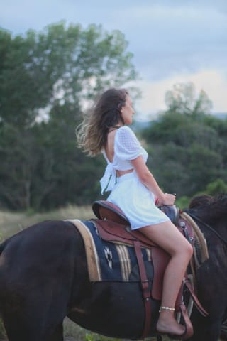 Woman riding a horse outdoors.