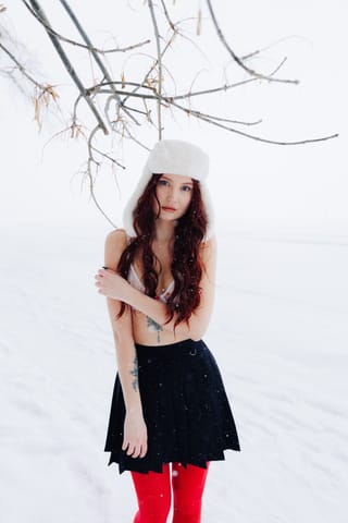 Woman wearing red tights in a snowy winter setting.