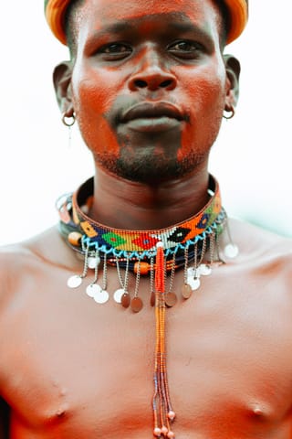 Man wearing colorful traditional beaded jewelry in a portrait.