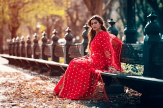 Woman red polka dot dress park bench