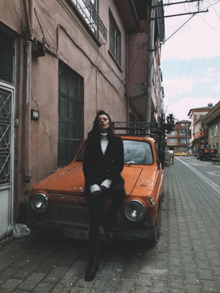 Woman black outfit orange vintage SUV street
