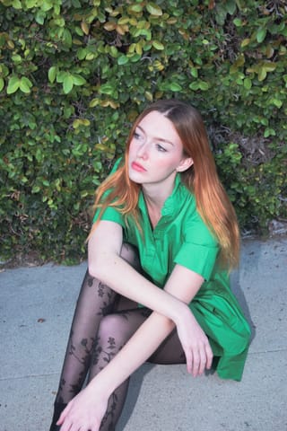 Woman green shirt ivy wall casual portrait