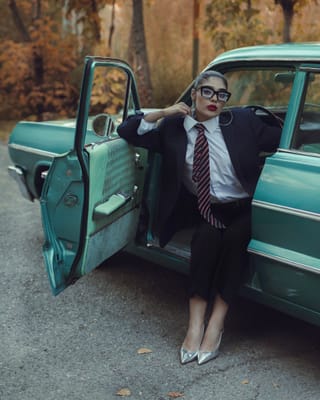 Businesswoman suit turquoise vintage car