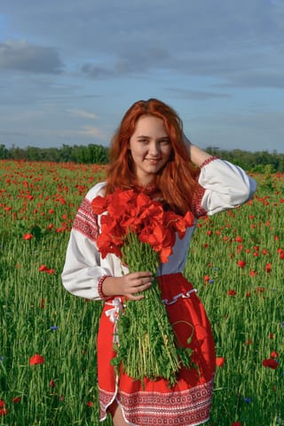 Redhead woman red dress poppy field portrait
