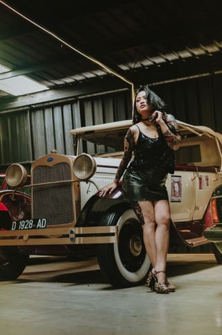 Woman black dress vintage car garage portrait