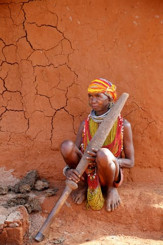 Man traditional clothing seated rustic wall