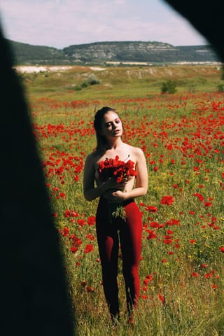 Woman black dress poppy field outdoor portrait