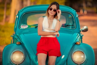 Woman red shorts turquoise vintage car