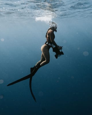 Underwater photographer freediving in the ocean.