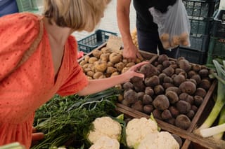 Woman shopping for fresh produce at a farmers market.