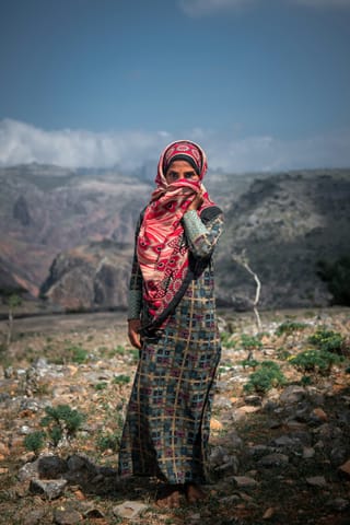 Woman in traditional clothing in a mountain village.