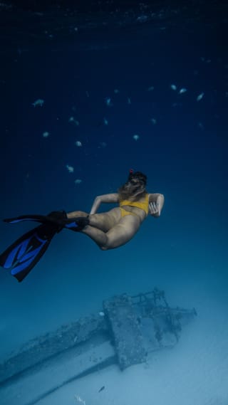 Freediver swimming underwater in the ocean.