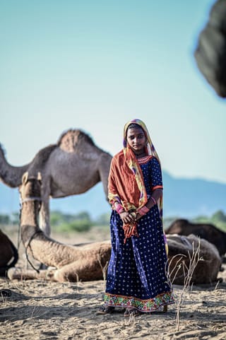 Woman with a camel in a desert travel portrait.