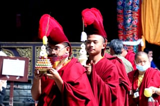 Buddhist monks in red robes during a cultural ceremony.