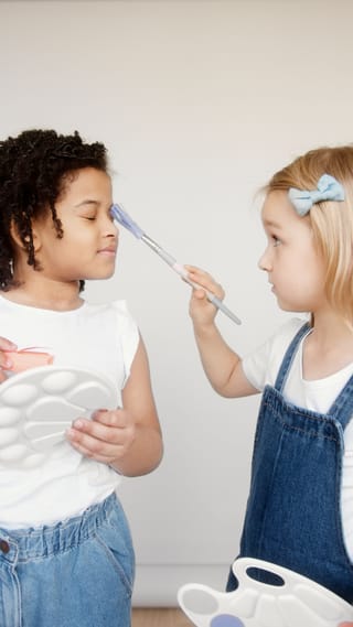 Friends applying makeup during a beauty routine.