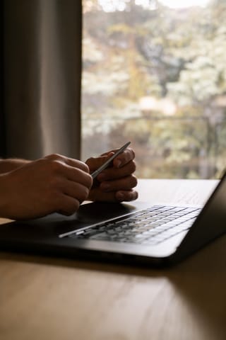 Hands typing on a laptop while working from home.