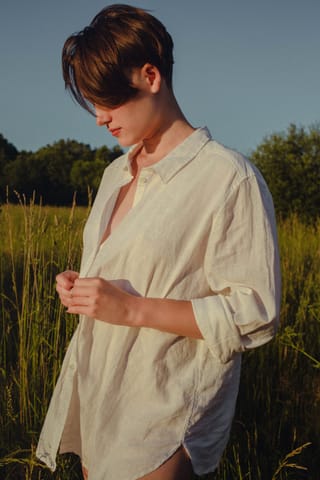 Person in a white shirt standing in a field.