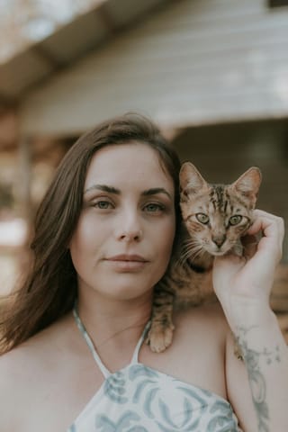 Woman holding a kitten in a close-up portrait.