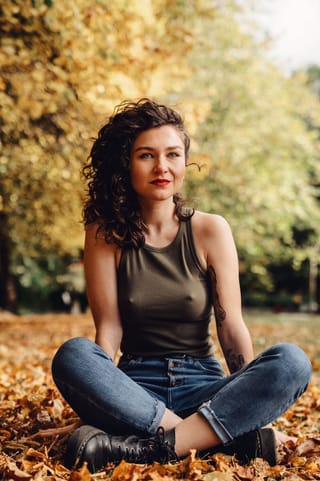 Woman meditating cross-legged in an autumn park.