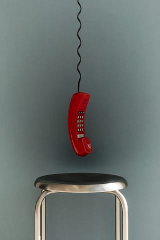 Red retro wall phone in a minimal interior.
