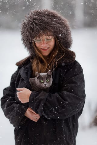 Woman in a winter coat and fur hat in the snow.