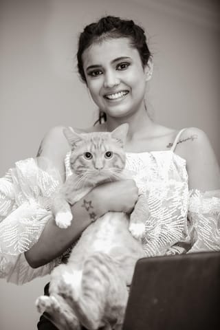 Smiling woman holding a cat in a black-and-white portrait.