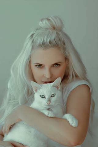 Blonde woman holding white cat pet portrait.