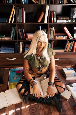 Blonde woman library black outfit fashion portrait.
