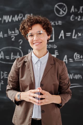 Female teacher math classroom chalkboard education.