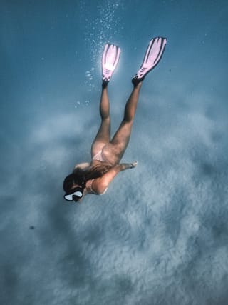 Freediver underwater long fins ocean diving.
