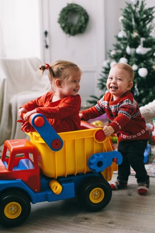 Kids playing toy truck christmas home.