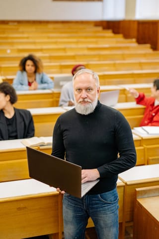 Male professor lecture hall laptop education.