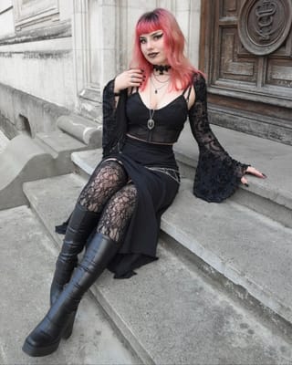 Red-haired woman gothic black lace dress boots.