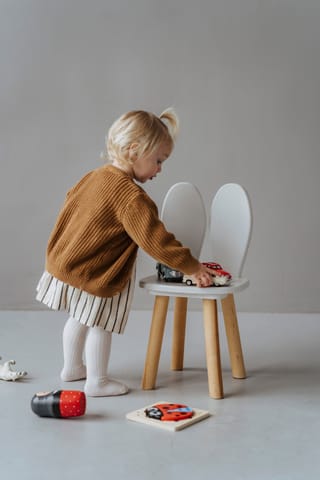 Toddler playing toy kitchen early learning.