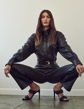 Woman black outfit wide-leg pants studio fashion.